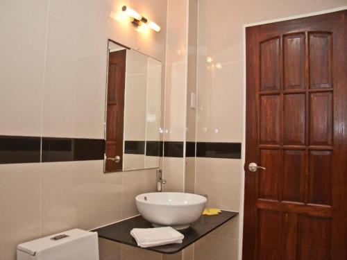 a bathroom with a sink and a mirror and a toilet at Caimito Beach Hotel in Ichon