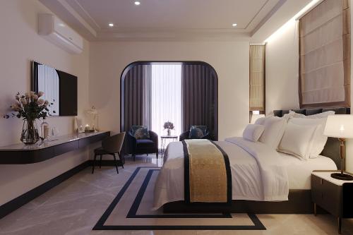 a bedroom with a large white bed and a desk at Anvi Boutique Hotel Hanoi in Hanoi