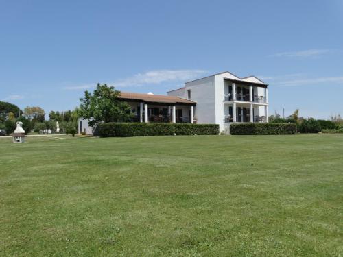 a large white house sitting in the middle of a grassy field at Il Pagio in Alghero