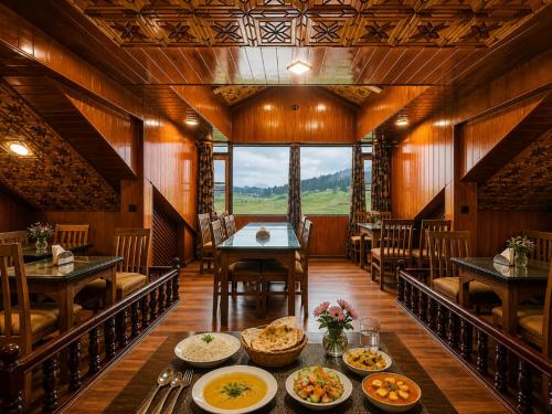 a dining room with a table with plates of food at Pine View Resort in Gulmarg