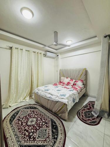 a bedroom with a bed and two rugs on the floor at Mombasa 1 Bedroom Apartment in Mombasa