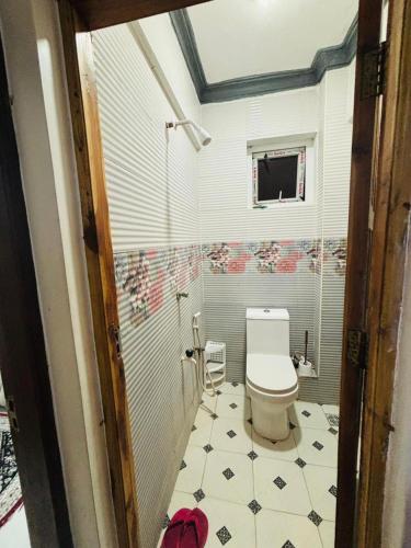 a bathroom with a toilet and a tiled floor at Mombasa 1 Bedroom Apartment in Mombasa