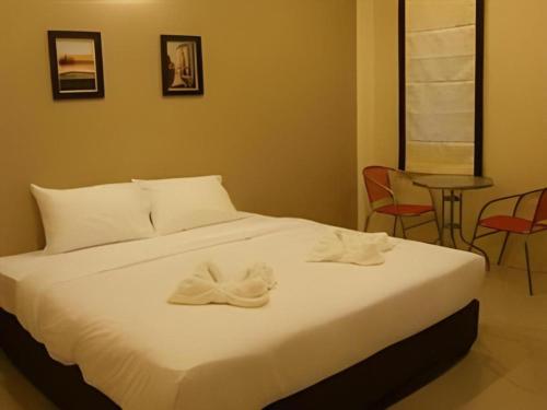 a bedroom with a bed with white towels on it at Surintara Resort in Surin