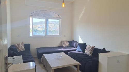 a living room with blue couches and a table at Acacia Nest in Tangier