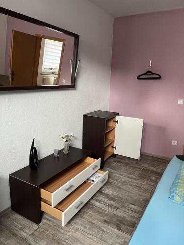 a room with a bed and a dresser and a mirror at Ferienwohnung Krayenbergblick 2 in Tiefenort