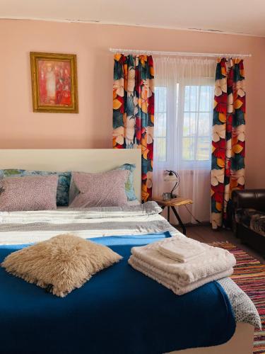 a bedroom with a large bed with a blue blanket at Chatka Oli in Zubacze