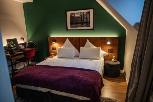 a bedroom with a large bed with a green wall at Das Mühlentor Hotel mit Restaurant - moderne Zimmer - leckere Heimatküche - familiär geführt in Bad Kreuznach