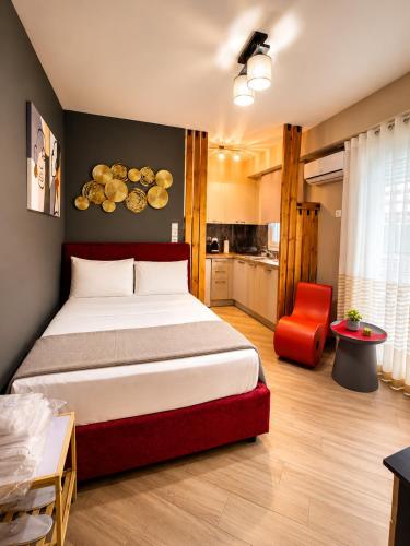 a bedroom with a large bed and a red chair at GPX CLR - MicroLuxe Suite in Larisa