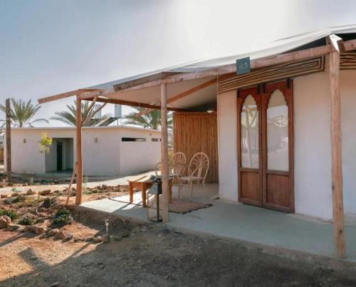 a house with a porch with a table and a chair at Amara Travel in Zuqim