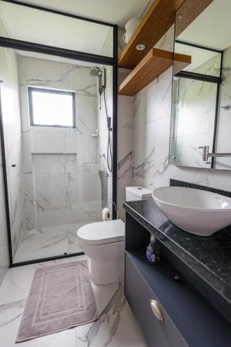 a bathroom with a sink and a toilet and a shower at Little Britain no centro de Pomerode in Pomerode