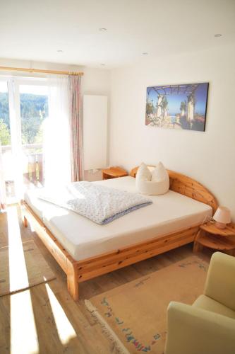 a bedroom with a large wooden bed in front of a window at Landhaus Lena in Schönwald