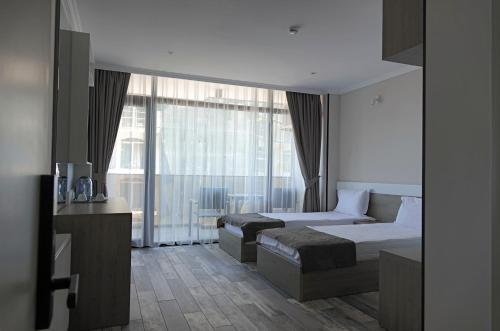 a bedroom with two beds and a large window at Hotel Green Rock in Kvariat'i