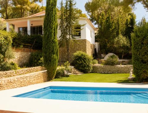 a swimming pool in front of a house at Villa Wanderlust Sitges Hills Exclusive pool only families in Olivella