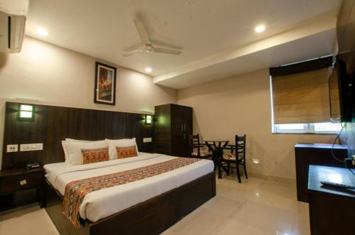 a bedroom with a large bed and a dining room at Hotel Jullundur 18 in Chandīgarh