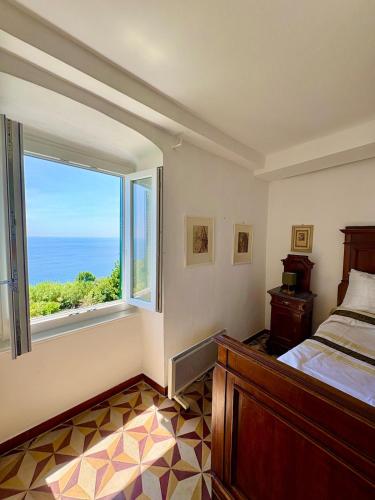 a bedroom with a bed and a large window at Appartamento con terrazza vista mare nel borgo in Framura