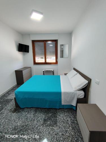 a bedroom with a blue bed and a window at Brezza Marina in Tortoreto Lido