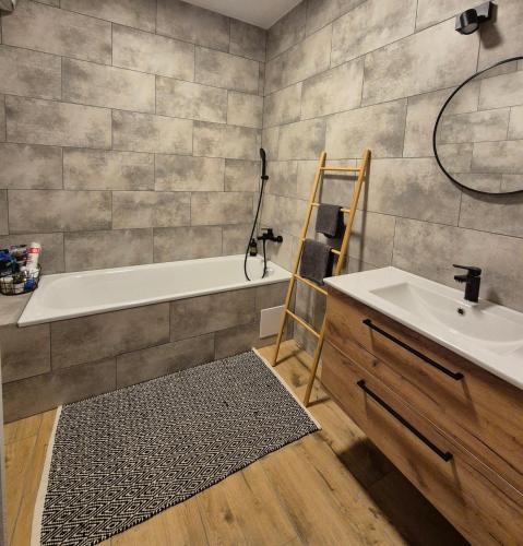a bathroom with a tub and a sink and a mirror at Apartmány Koliba in Turčianske Teplice