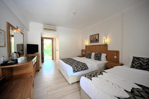 a hotel room with two beds and a couch at Belcehan Hotel in Oludeniz