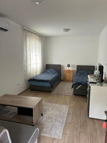 a living room with two beds and a table at Rooms Lepara in Konjic