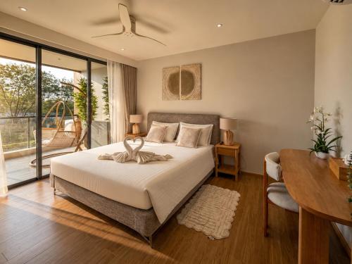 a bedroom with a bed and a table and a desk at Laguna Seaside 3 bed #84195 in Bang Tao Beach