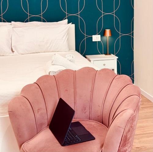 a laptop sitting on a chair in front of a bed at Suite in Centro in Vasto