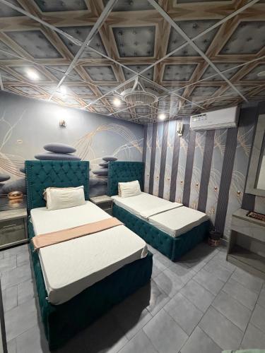 a room with two beds in a room at Karachi Family Guest House in Karachi