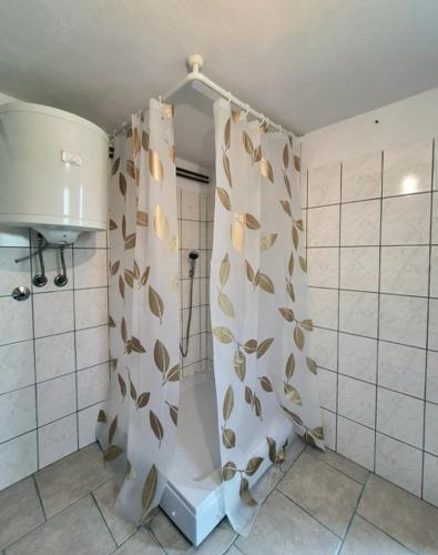 a bathroom with a shower curtain with leaves on it at Rooms-Zejnep SARAJEVO in Sarajevo