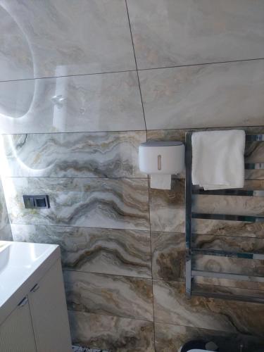 a bathroom with a stone wall with a towel at zatyshnyy dvoryk Затишний Дворик in Kolomiya