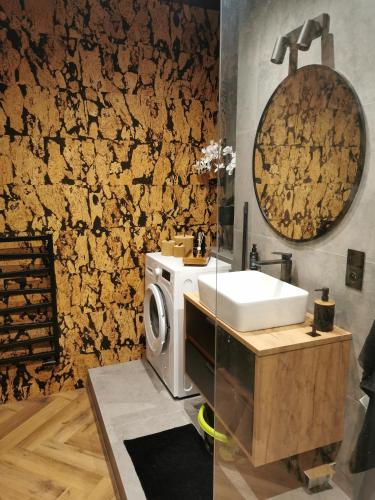 a bathroom with a sink and a washing machine at Apartament Kamil Kalisz in Kalisz