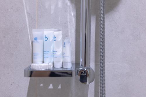 a bunch of toiletries on a shelf in a bathroom at Jasmine Garden Makkah in Al Masfalah