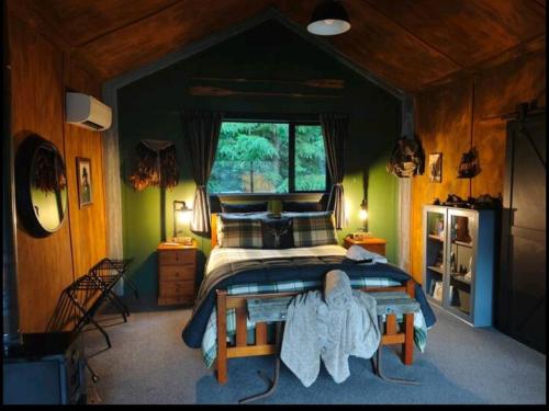a bedroom with a bed in a room with green walls at Hut on The Grove in Twizel
