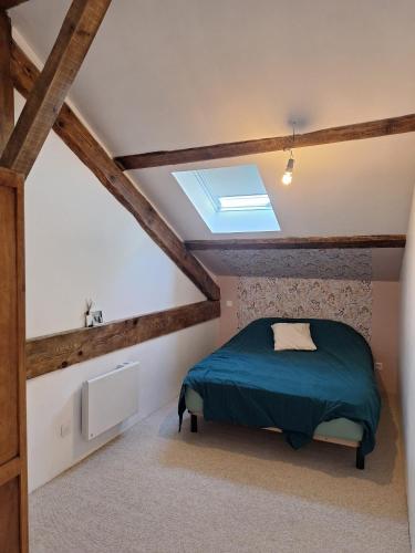 a attic bedroom with a bed and a skylight at La maison COP&CO in Murat-sur-Vèbre