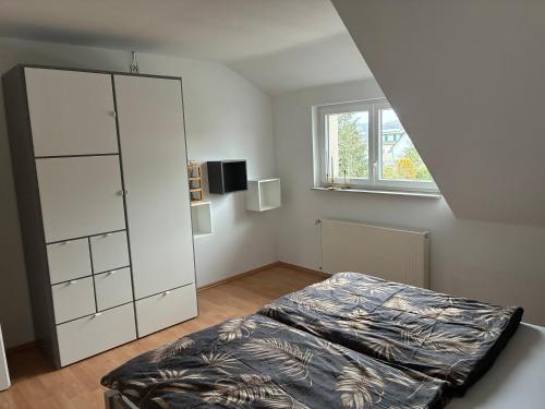 a bedroom with a bed and a white cabinet at FeWo Saier in Althengstett