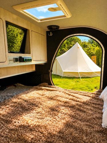 a tent in an rv with a white tent in the grass at Glamping Privé 2 tentes pour vous sur le mont à Tilff in Esneux