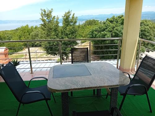 a table and chairs on a balcony with a view at D,apartman' ulica pušća 51, 51513 Omišalj in Omišalj