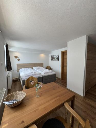 a room with two beds and a wooden table at Haus Krone in Lähn