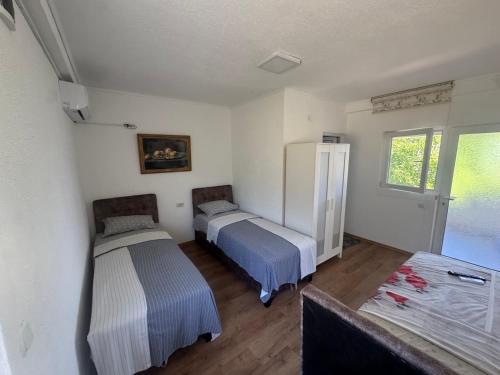 a bedroom with two beds and a window at Apartmani Konak in Star Dojran