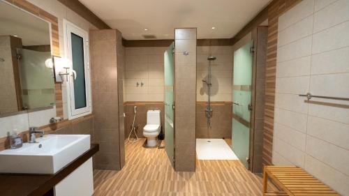 a bathroom with a sink and a shower and a toilet at شالية 280 in Dammam