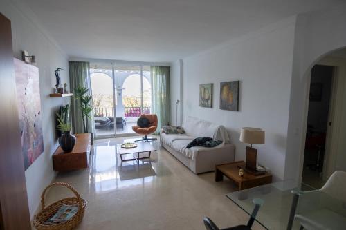 a living room with a white couch and a table at appartement gelegen aan de golfbaan op La Quinta Benahavis Marbella in Benahavís