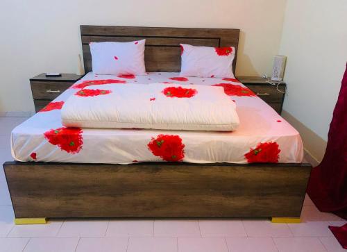 a bedroom with a bed with red flowers on it at Catalan du walo in Richard Toll