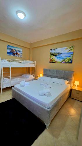 a bedroom with a large bed and bunk beds at Villa Alvara in Vlorë