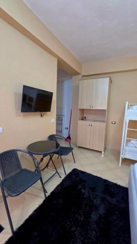 a living room with a table and chairs and a television at Villa Alvara in Vlorë