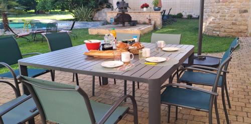 a picnic table with food and drinks and chairs at La Belle Bourguignonne in Crêches-sur-Saône