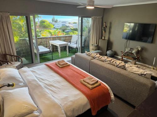 a living room with a bed and a large window at 78on5th in Hermanus in Hermanus