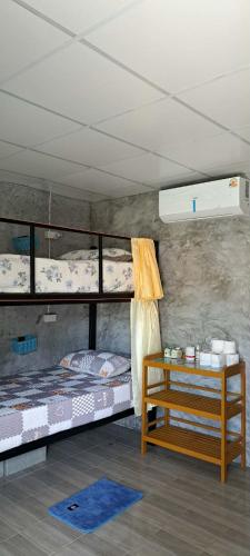 a room with two bunk beds and a table at Yao Noi Hostel by KR in Ko Yao Noi