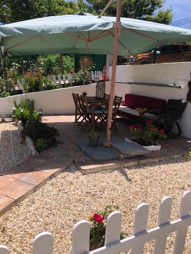 a patio with a table and an umbrella at Casita la 'Dore in Cariño