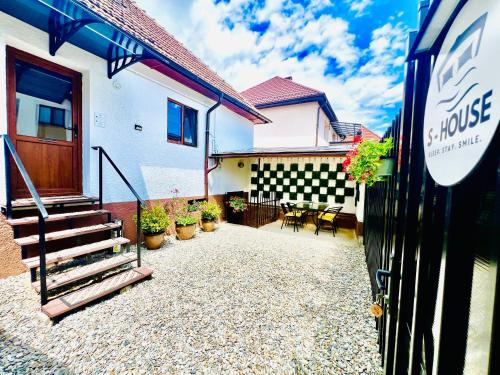 a house with a patio with a table and chairs at S-HOUSE Avrig , Apartament cu Aer Condiționat, 2 Dormitoare, Bucatarie, Terasa , Curte Privată Parcare Gratuită in Avrig