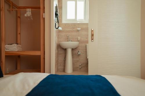a bathroom with a sink and a shower with a bed at Zuma Hotel Cyprus - Turkish Side in Nicosia