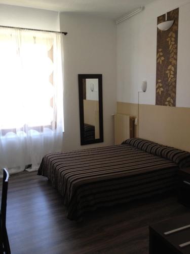 a hotel room with two beds and a mirror at Hôtel de la Citadelle in Sisteron