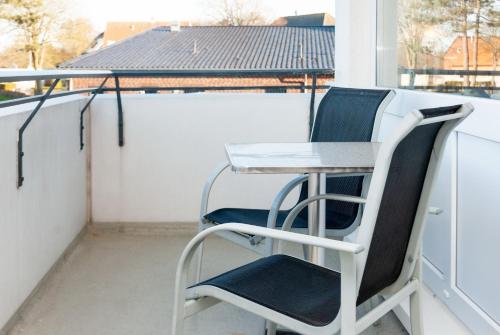 a small table and two chairs on a balcony at Hanseatic 110 in Duhnen